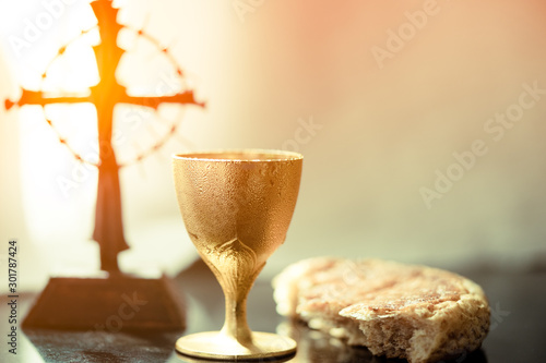Holy communion on wooden table on church.Taking holy Communion.Cup of glass with red wine, bread.The Feast of Corpus Christi Concept. photo