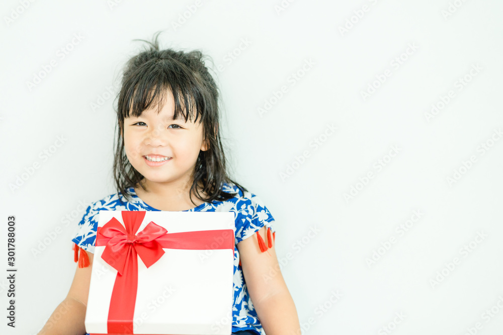Little asian girl smile and holding red gift box on white background.child holding gift box. Little asian girl smile and holding red gift box on white background.child holding gift box.