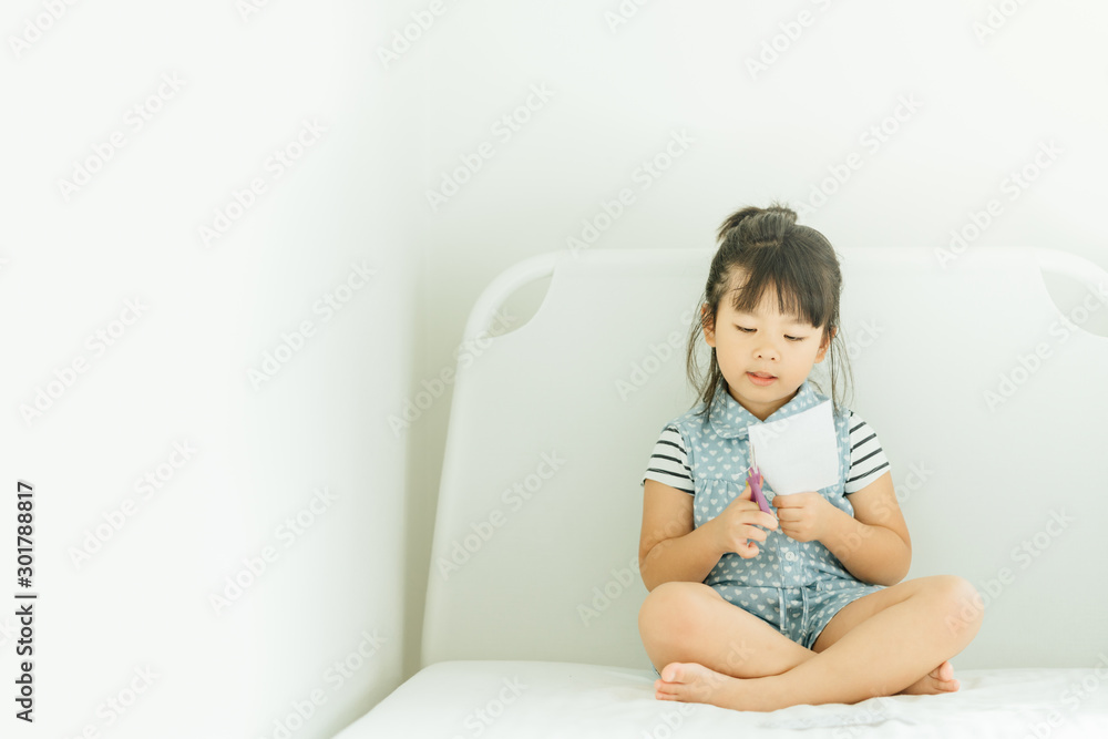 Portrait of a little asian girl cutting a paper in activities on DIY class at Home School.Scissors cut paper.Art craft paper. Portrait of a little asian girl cutting a paper in activities on DIY class at Home School.Scissors cut paper.Art craft paper.