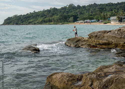 Phu Quoc / Vietnam - July 2019: A man fishing on the beach in the island of Phu Quoc, Vietnam.