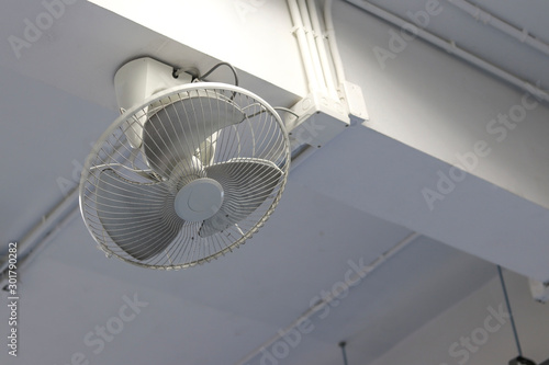 White fan mounted on the beam. Wall mounted fans mounted on top.