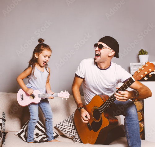 Papier peint singes - Papier peint Beautiful little girl playing guitar with her father. Funny lifestyle picture. Happy family timespending. Girl holding pink ukulele ang singing and jumping,