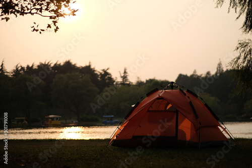 one tent by the lake at bright sunset in park.blur background