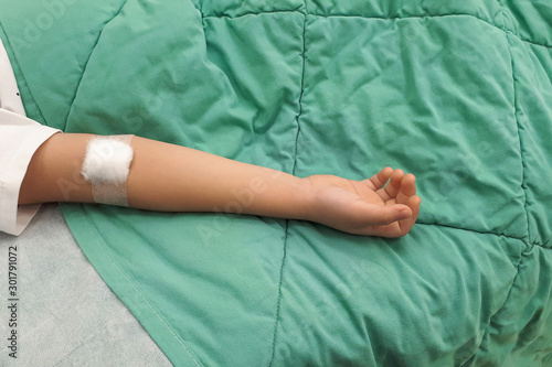 Child's hand in a hospital bed. iv drip in hand Child's in a hospital bed