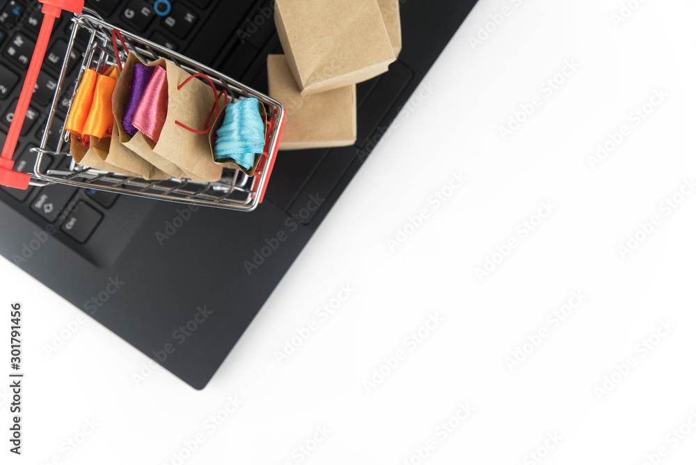 Shopping cart with purchases - packages and boxes on the modern laptop. Online shopping, black friday and sale concept. Shopping cart with purchases - packages and boxes on the modern laptop. Online shopping, black friday and sale concept.