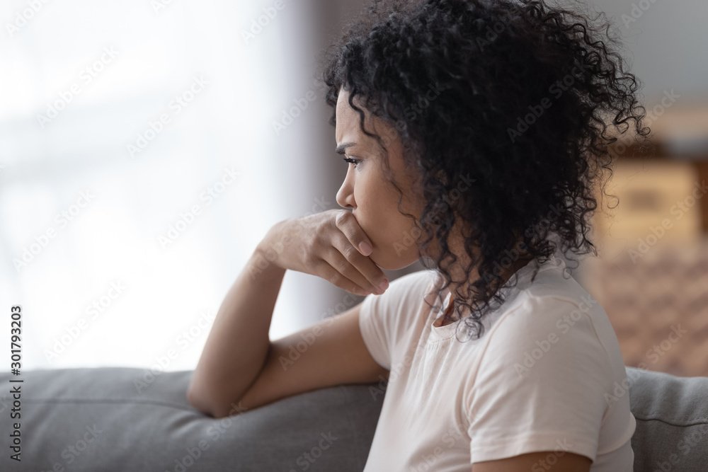 Upset African American woman thinking about problems close up Upset African American woman thinking about problems close up