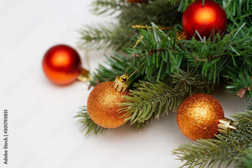 Spruce paws with gold christmas balls on white background