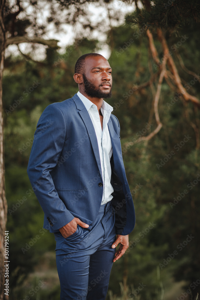 african man in a business suit in the forest