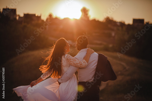 Lovely mixed couple is watching the sunset
