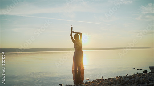 silhouette of a dancing girl on a background sunset. beautiful girl dancing and having fun outdoors. Girl dancing at dawn