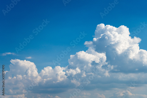 Glowing clouds on a background of blue sky. White fluffy luminous cloud photo