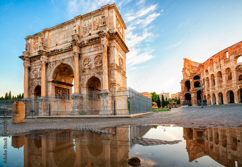 Arch of Constantine and Colosseum in Rome reflection in puddle after rain, Italy. Triumphal arch in Rome, Italy. North side, from the Colosseum. Colosseum is one of the main attractions of Rome.
