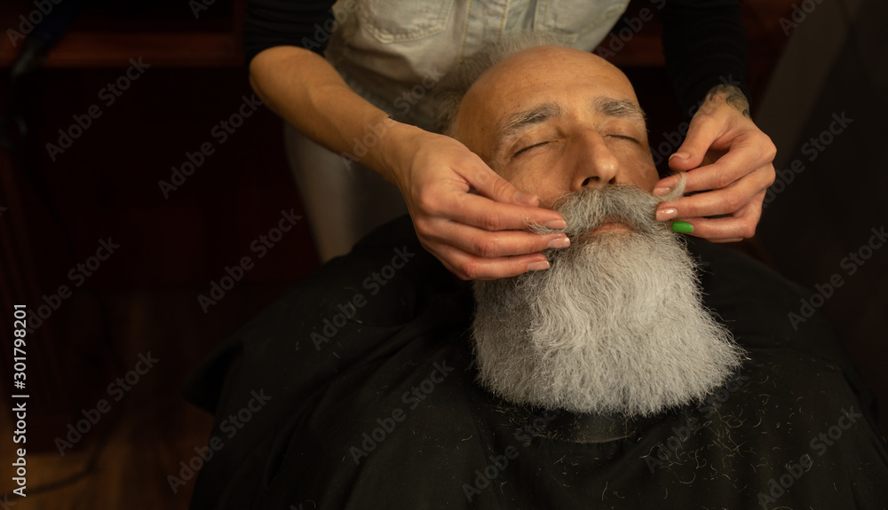 Shaving process of beards in Barbershop. Master makes a haircut beard client with vintage straight razor. Shaving process of beards in Barbershop. Master makes a haircut beard client with vintage straight razor.