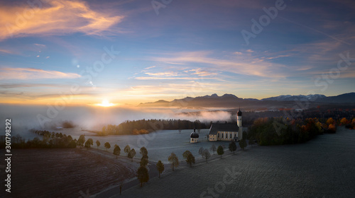 Beautiful foggy autumn morning in Bavaria - aerial view of Wilparting Church before Alps in Chiemgau photo