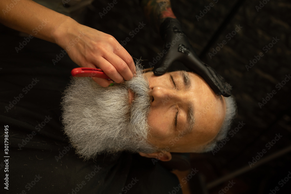 Shaving process of beards in Barbershop. Master makes a haircut beard client with vintage straight razor. Shaving process of beards in Barbershop. Master makes a haircut beard client with vintage straight razor.