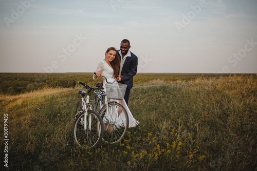 african american man and european woman riding bikes in the field