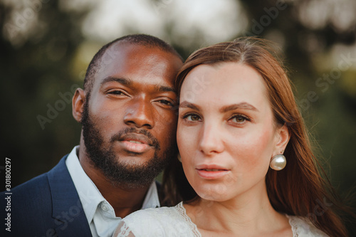 happy and beautiful mixed ethnicity couple with beautiful afro American man and cheerful europian woman loking in different directions