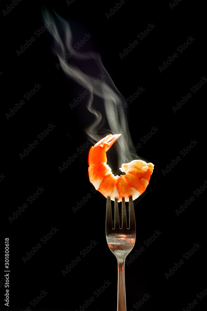 shrimp on the fork with dark background. shrimp with steam and smoke on fork close up.selective focus tiger shrimp on silver fork, food concept shrimp on the fork with dark background. shrimp with steam and smoke on fork close up.selective focus tiger shrimp on silver fork, food concept