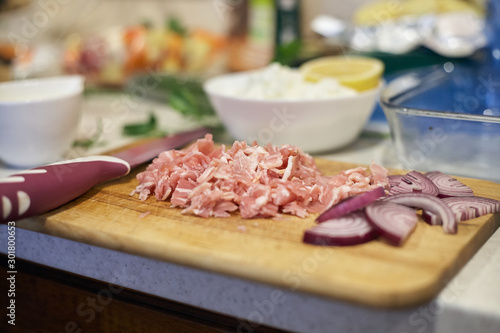 Cutted ham and onion on the table of the kitchen.