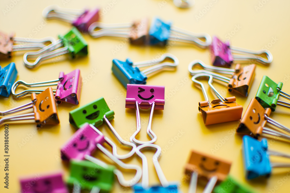 emotion on paper clip on yellow background. subject is blurry. emotion on paper clip on yellow background. subject is blurry.