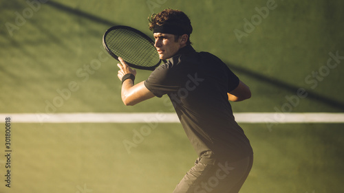 Young player playing tennis on hard court © Jacob Lund