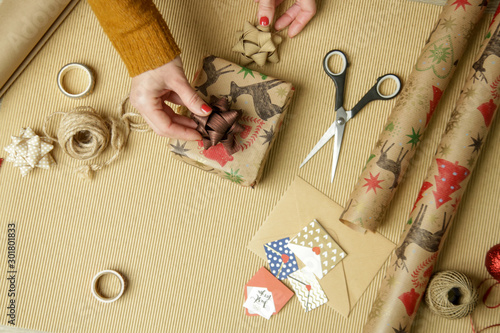 Woman wrapping Christmas presents, winter hoildays,  gifting season concept photo