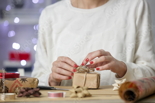 Woman wrapping Christmas presents, winter hoildays,  gifting season concept photo