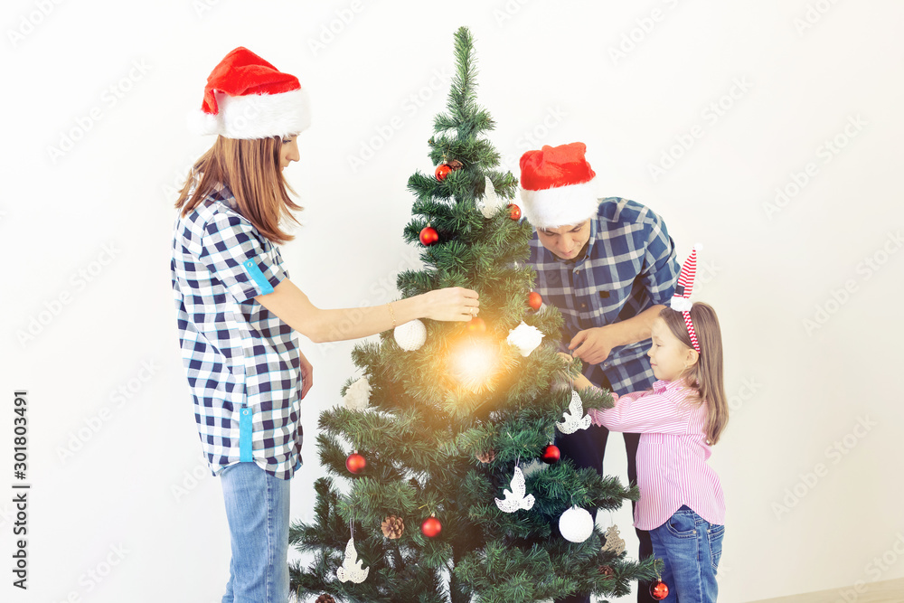 Holidays, x-mas and celebrating concept - Happy family decorating Christmas tree in holiday on white background Holidays, x-mas and celebrating concept - Happy family decorating Christmas tree in holiday on white background
