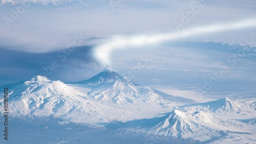 Eruption smoke from volcano's peak in snowy landscape, Klyuchevskoy volcano in Siberia Russia animation. Contains public domain image by Nasa photo