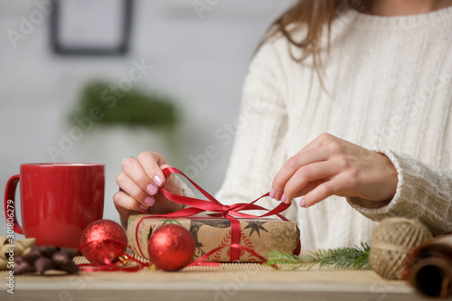 Woman wrapping Christmas presents, winter hoildays,  gifting season concept photo