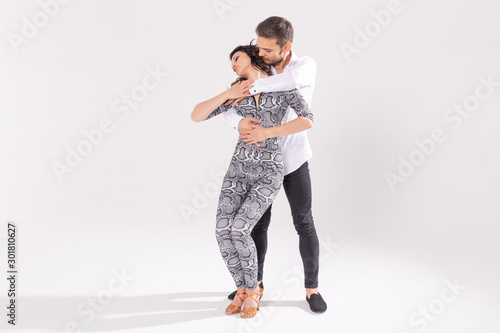 Fototapeta Naklejka Na Ścianę i Meble -  Social dance, bachata, kizomba, zouk, tango concept - Man hugs woman while dancing over white background with copy space