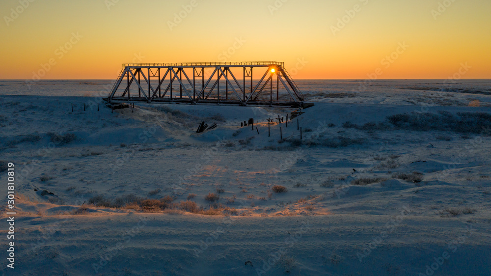 Winter Landscape of the forest-tundra, railway bridge, bird's eye view at sunset. Arctic Circle, tundra. Beautiful landscape of tundra from a helicopter.