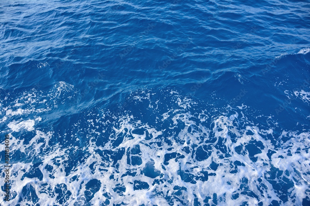 Fototapeta premium Blue sea water background and waves with sea foam