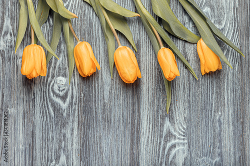 Bright yellow tulips on a wooden table.