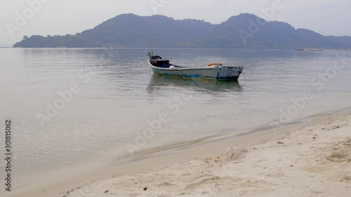 Wooden fishing boat in the Penang Strait with Jerejak Island in the background, Georgetown, Malaysia. photo