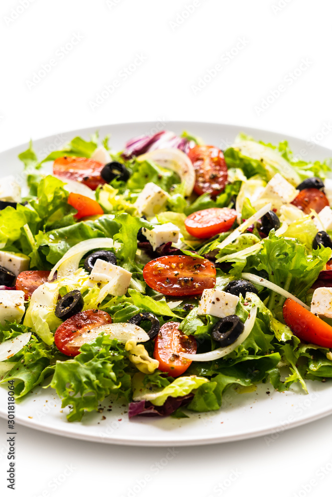 Fresh greek salad on a plate on white background