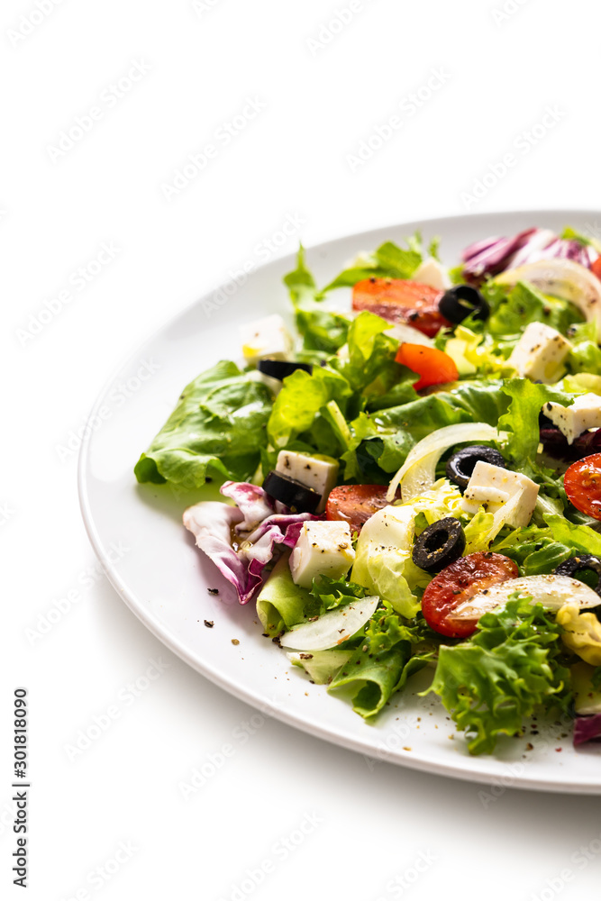 Fresh greek salad on a plate on white background Fresh greek salad on a plate on white background