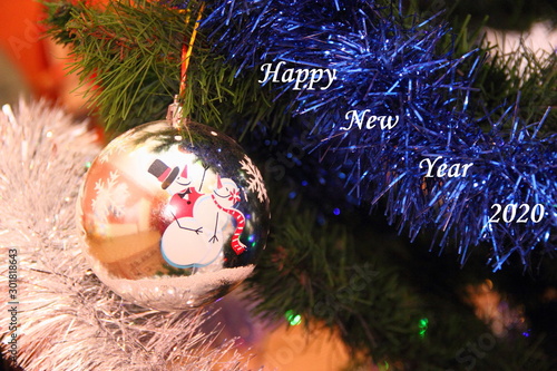 Fir branch tinsel with Christmas ball with dancing snowmen and inscription Happy new year 2020 photo