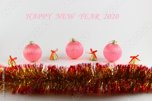 Happy new year 2020 pink text with pink  Christmas balls, yellow bells and yellow red tinsel photo