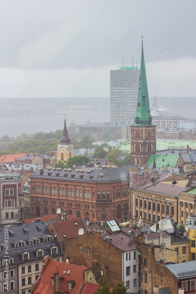 Aerial view of St. James's Cathedral or the Cathedral Basilica of St. James, Riga castle, Old Town and River Daugava from Saint Peter church on cloudy, foggy and rainy day, Riga, Latvia. Soft focus
