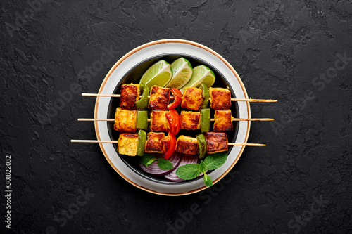Cuadro en lienzo Paneer Tikka at skewers in black bowl at dark slate background
