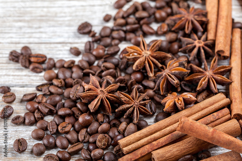 Star anise, cinnamon and roasted coffee beans. Aromatic spices on wooden background. Top view. Close up. Seasoning ingredients for cooking or baking