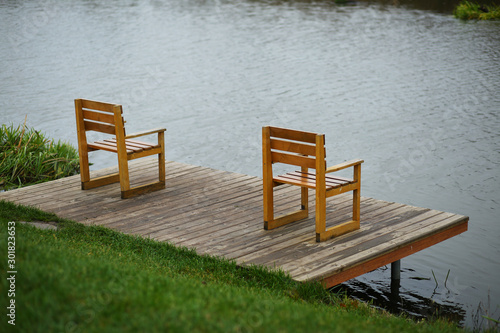 Empty wooden chairs at the river bank dock, landscape design