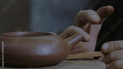close-up of a potter marking the base of a clay teapot for attaching a spout for a teapot. Yixing clay teapot for Chinese tea ceremony . 4k video. 59.94 fps