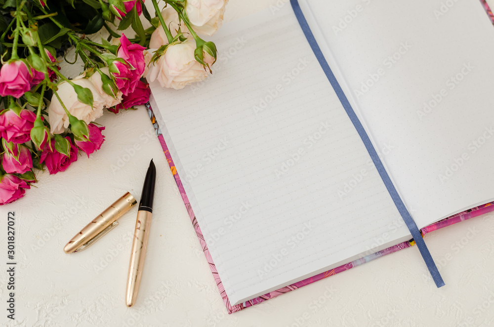 Goal planning concept. Open notebook on the table, pen and roses Goal planning concept. Open notebook on the table, pen and roses