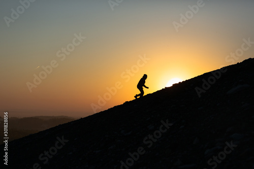 Фотография A man running uphill at sunrise