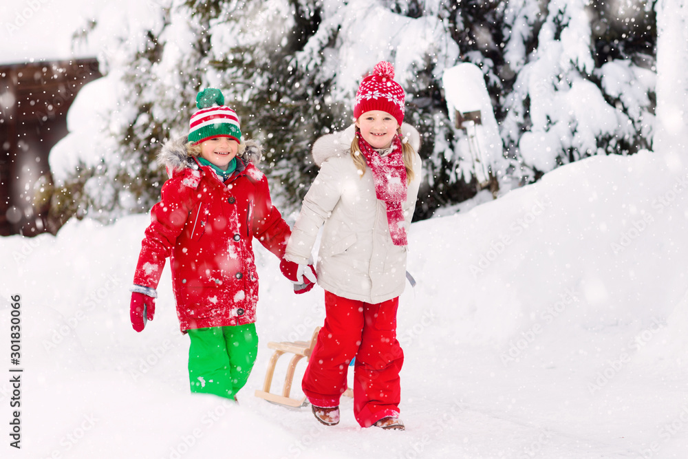 Kids play in snow. Winter sleigh ride for children