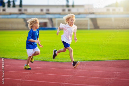 Child running in stadium. Kids run. Healthy sport. © famveldman