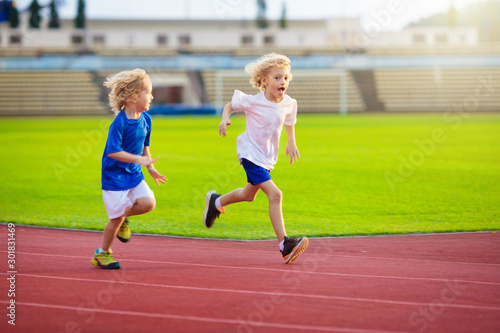 Child running in stadium. Kids run. Healthy sport.