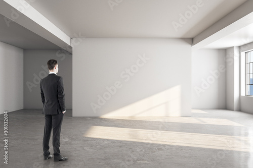 Businessman looking at blank wall